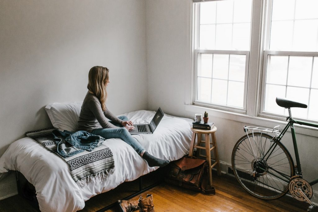 woman-in-gray-shirt-sitting-on-bed-3954635-1024×682